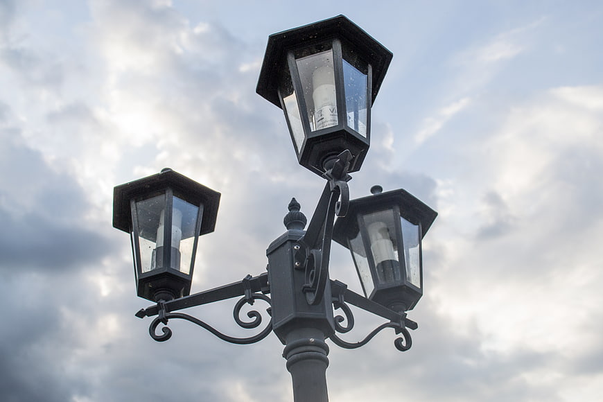 Vintage black street lamp against cloudy sky