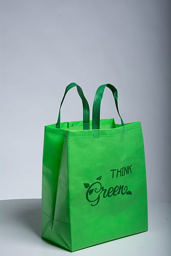 Green non-woven tote bag with Think Green slogan on grey background