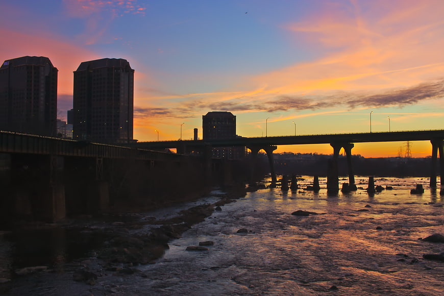 City skyline and bridge over river at sunset