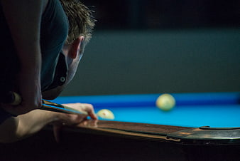 Man Playing Pool in Dimly Lit Hall