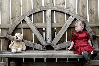 Toddler Girl in Red Dress Sitting on Wooden Bench with Teddy Bear