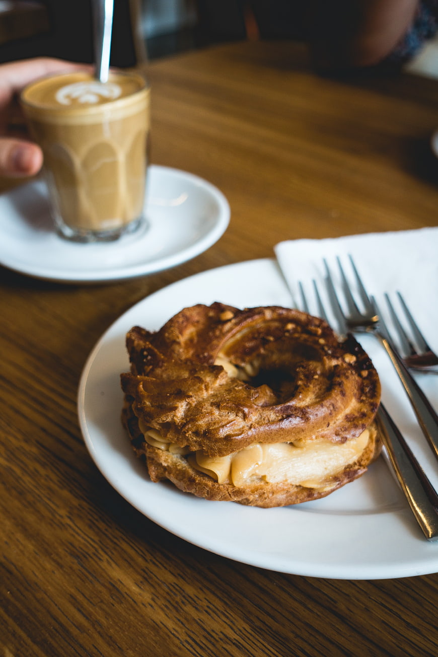 Peanut butter cream puff pastry with iced latte on wooden table
