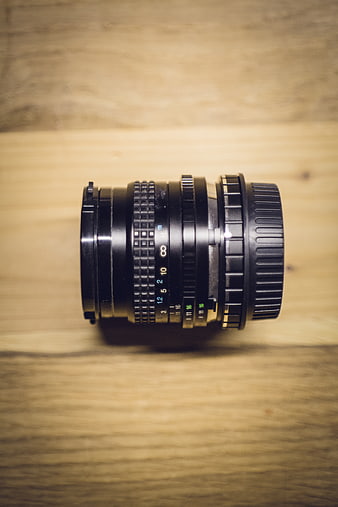 Vintage black camera lens on wooden table background