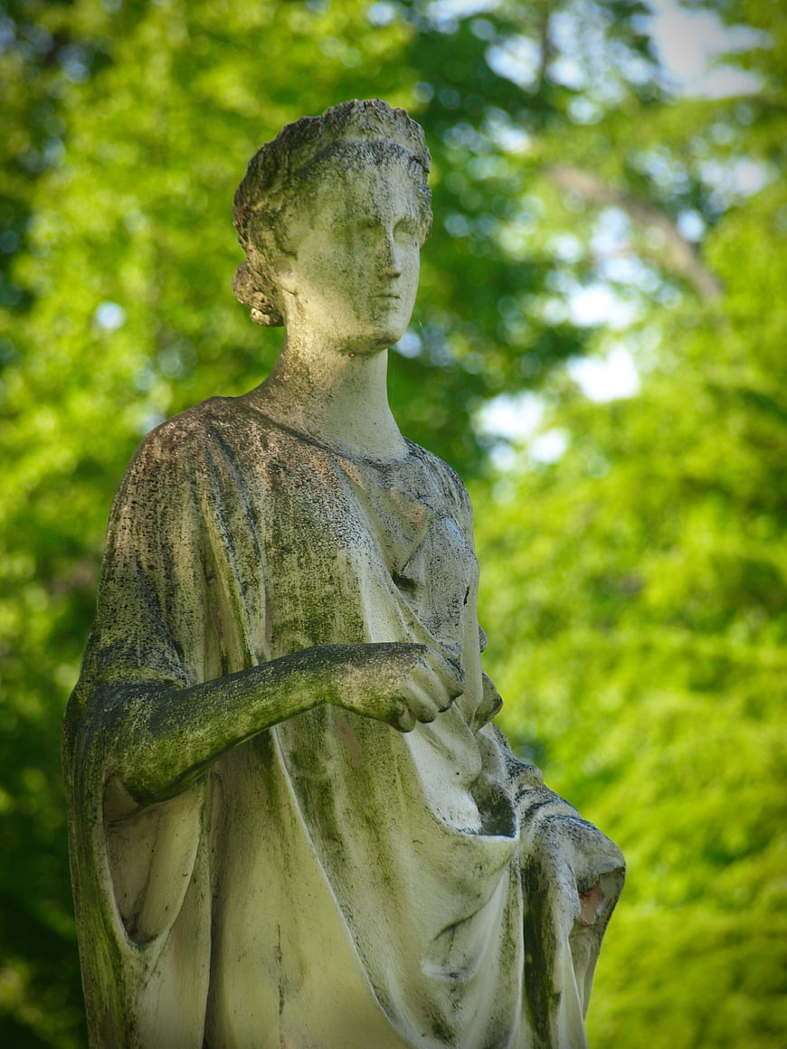 Weathered Stone Statue of Woman in Garden