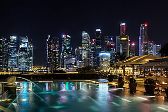 Singapore skyline at night with illuminated skyscrapers and pool