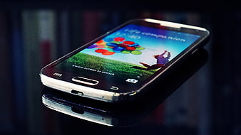 Smartphone with colorful screen on reflective surface