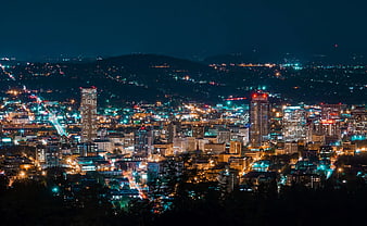 Vibrant city skyline illuminated at night with traffic trails