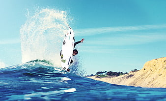 Surfer performing aerial maneuver on ocean wave