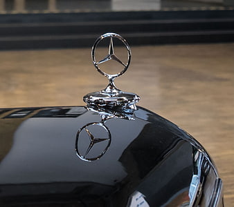 Close-up of classic Mercedes-Benz hood ornament on black car