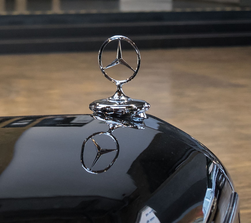 Close-up of classic Mercedes-Benz hood ornament on black car