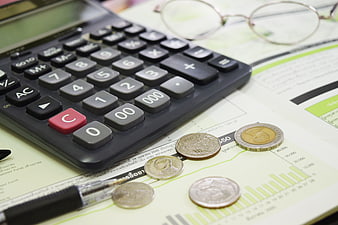 Calculator, coins, and financial documents on a desk