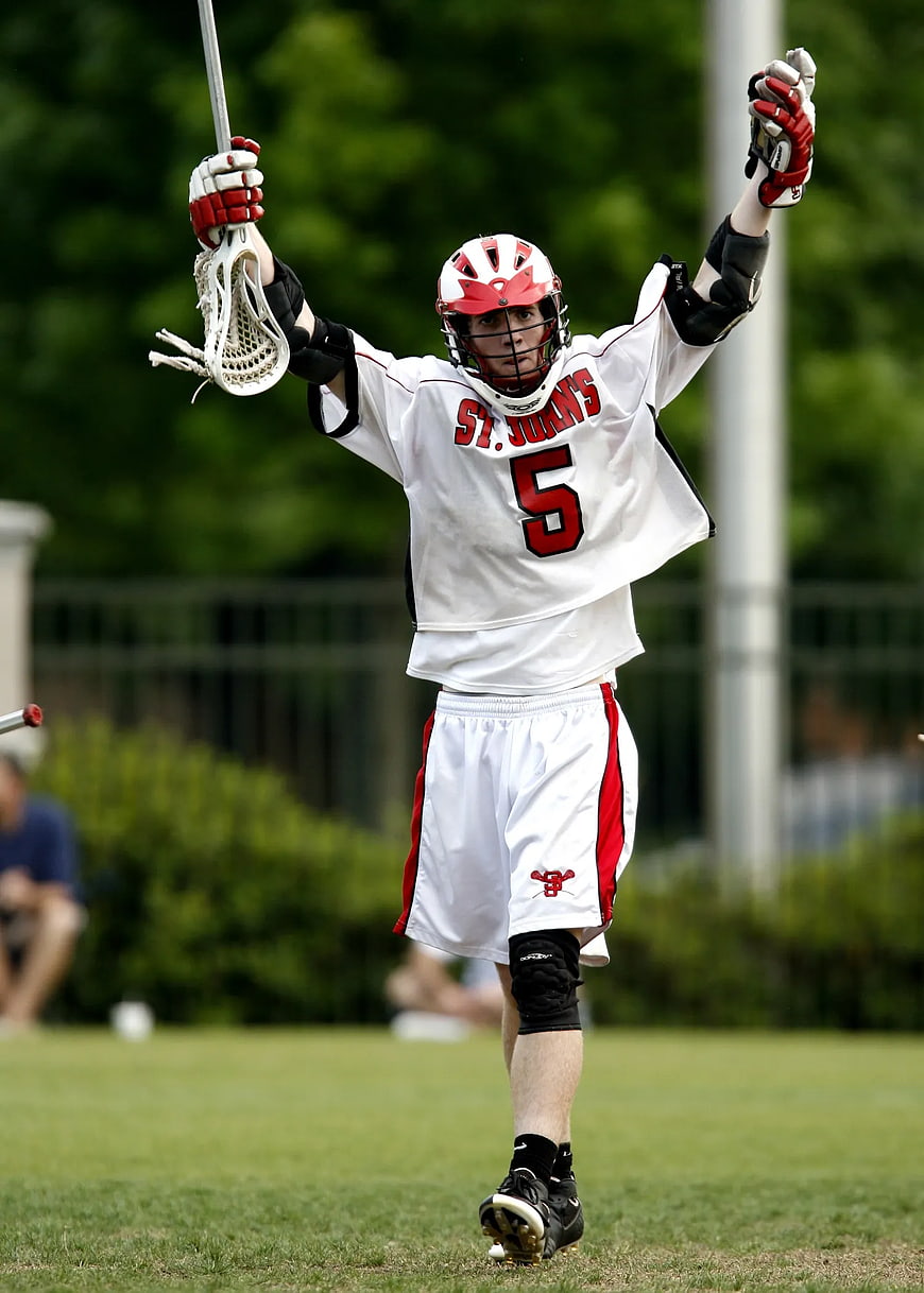 Lacrosse Player Celebrating Victory on Green Field