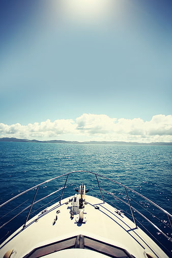 Sailboat bow view on blue ocean with distant mountains
