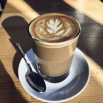Latte Art Coffee in Glass Cup on Wooden Table