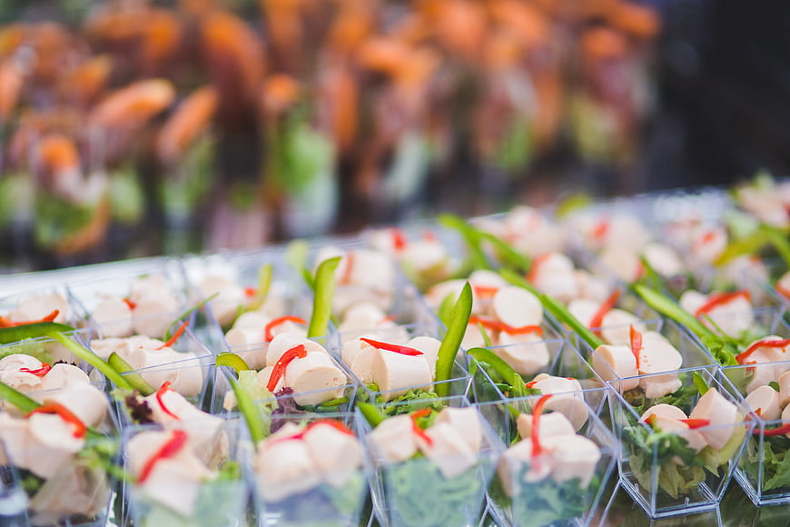 Rows of appetizer cups with chicken and vegetables