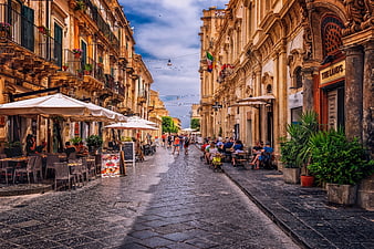 Historic European Street Scene With Outdoor Cafes And Pedestrians