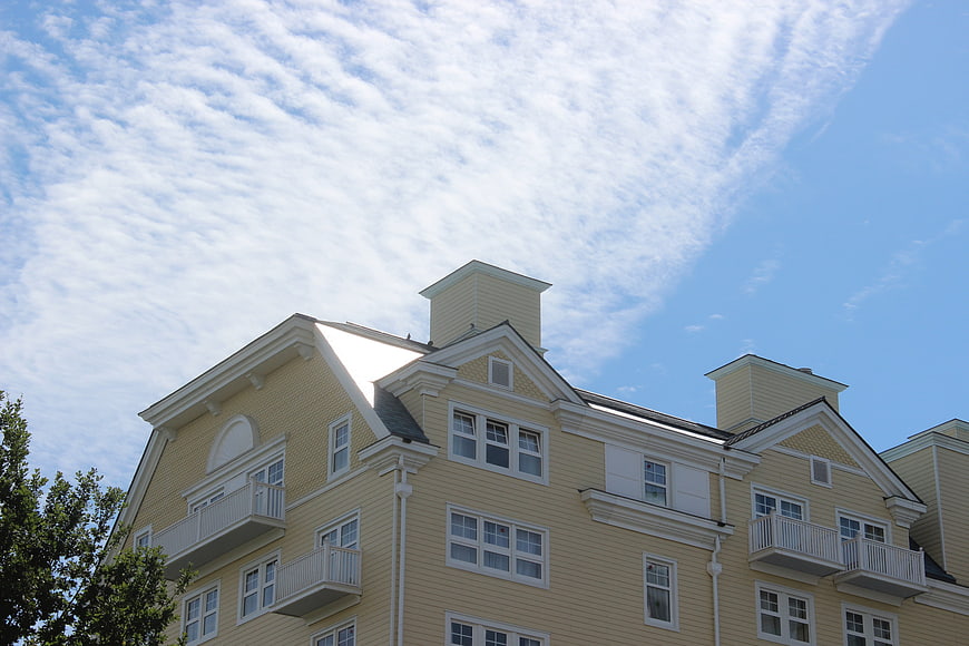Yellow multi-story hotel building with balconies against blue sky