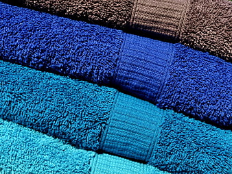Stack of folded blue and brown terry cloth towels texture