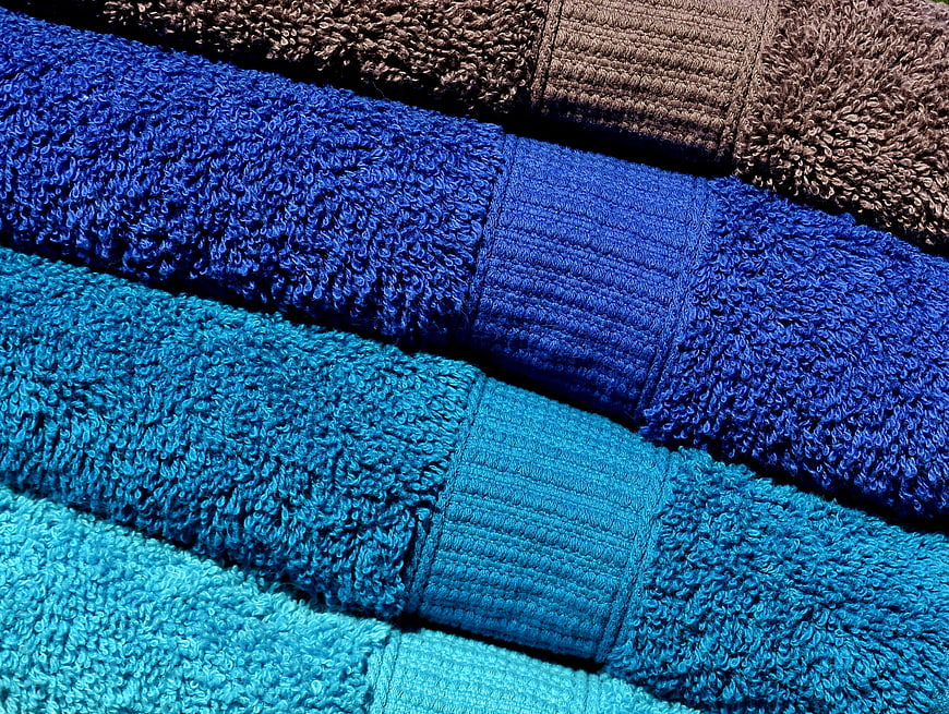 Stack of folded blue and brown terry cloth towels texture