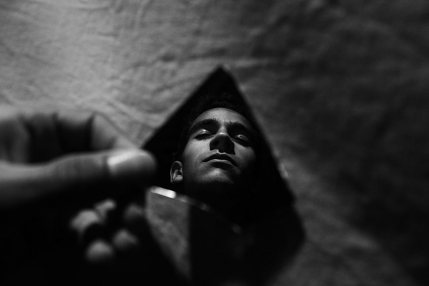 Man's reflection in a broken mirror shard in black and white