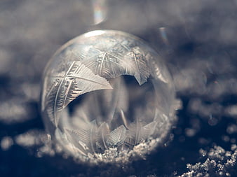 Macro photography of a frozen ice bubble with frost crystals