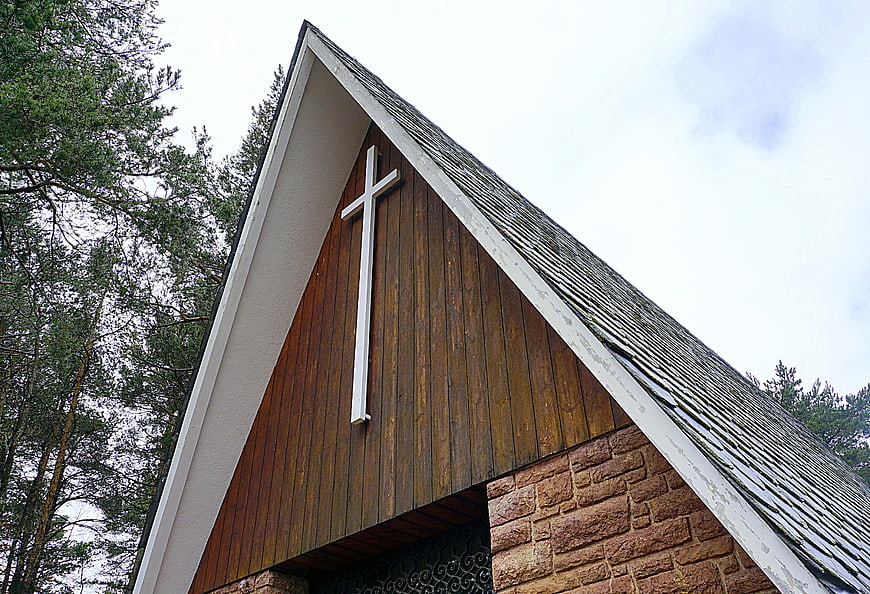 Low angle view of wooden chapel with white cross