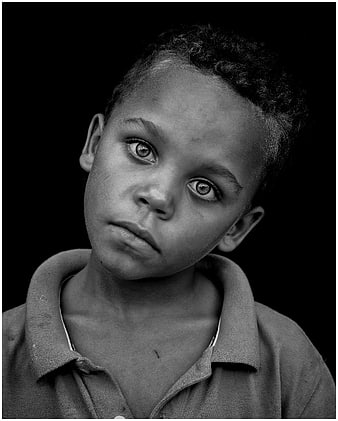 Black and white portrait of a young boy looking at camera