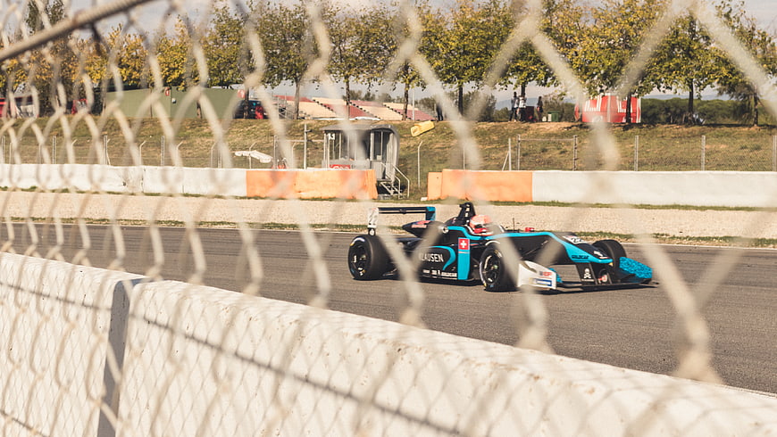 Formula E race car speeding on track through fence