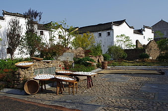 Traditional Chinese Village with White Walls and Drying Baskets