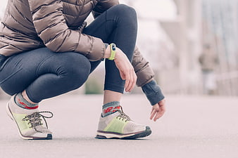 Runner Checking Smartwatch While Squatting Outdoors