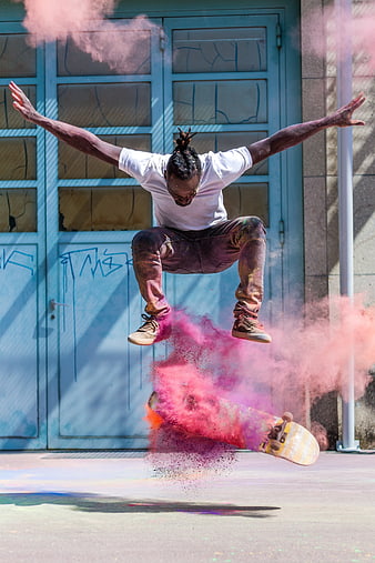 Skateboarder Jumping with Pink Smoke Explosion