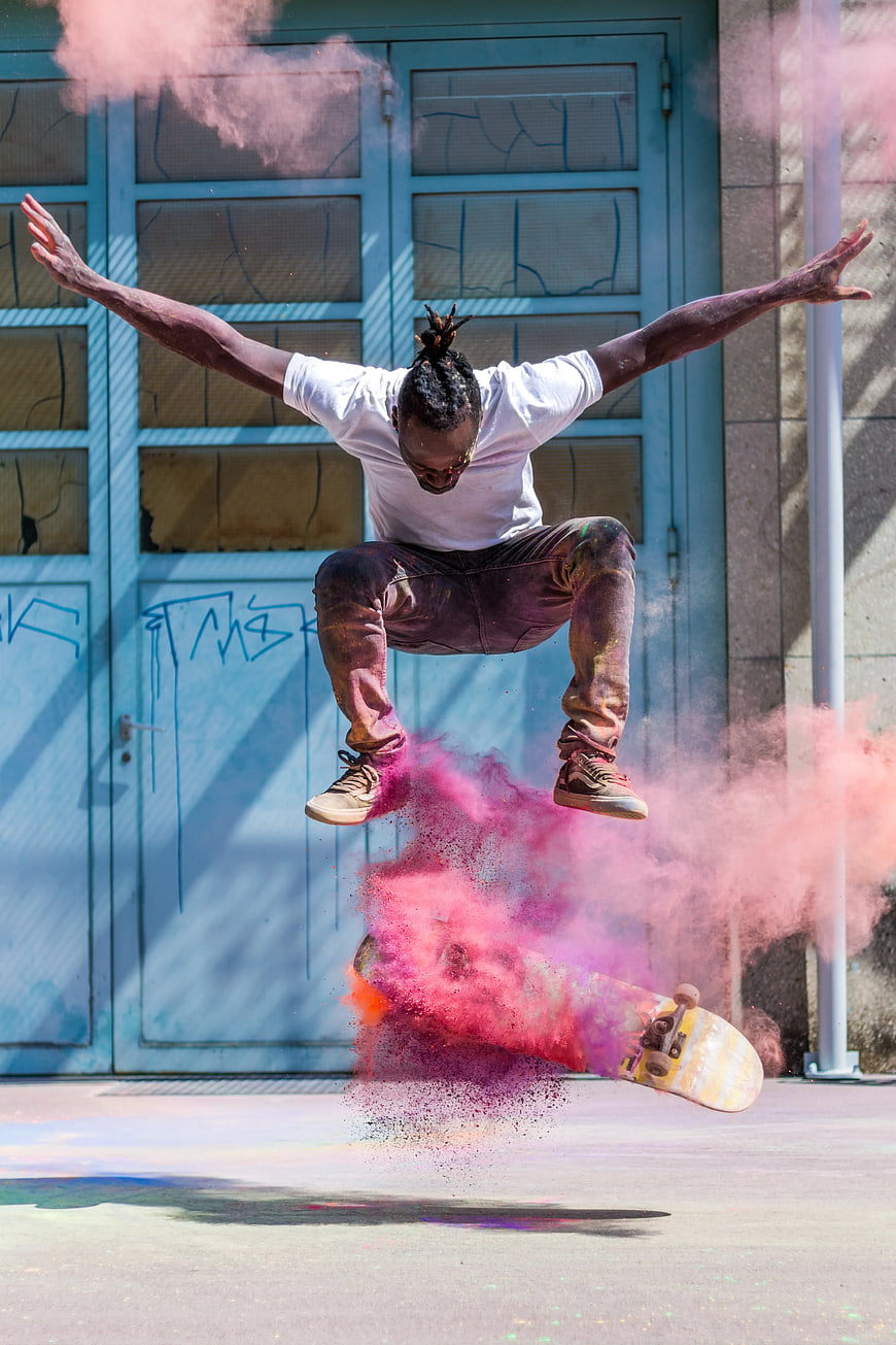 Skateboarder Jumping with Pink Smoke Explosion