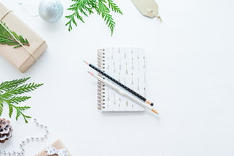 Christmas flat lay with notebook, pencils, and festive decorations