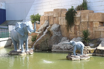 Elephant statues in a water fountain with rock waterfall