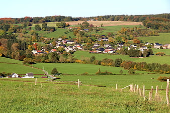 Scenic autumn village nestled in rolling green hills