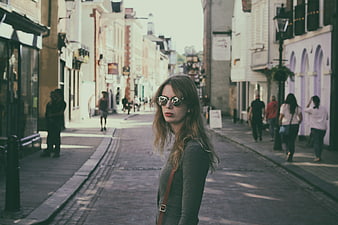 Woman with Sunglasses on Cobblestone Street