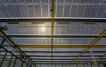 Industrial greenhouse roof with solar panels and yellow beams