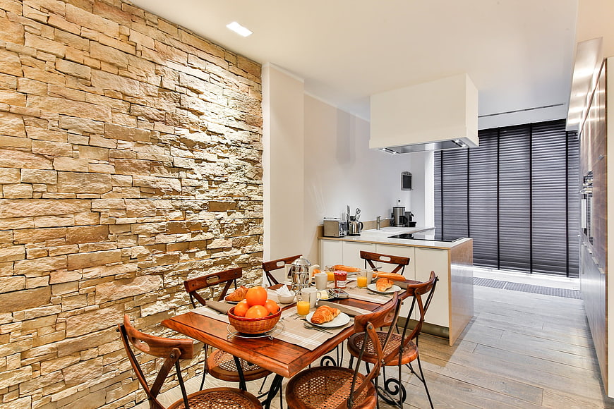 Modern Open Kitchen And Dining Area With Rustic Stone Wall