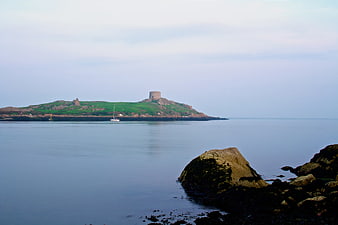 Serene coastal landscape with historic tower on green island