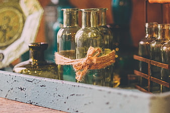 Vintage green glass bottles tied with twine in rustic tray