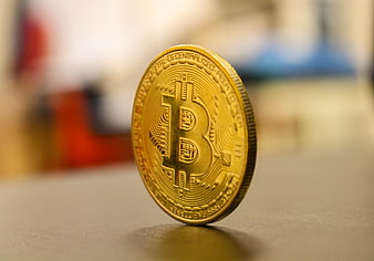 Physical Bitcoin Coin Standing Upright on Desk Surface