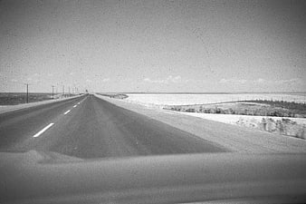 Vintage black and white photo of empty highway driving through flat landscape