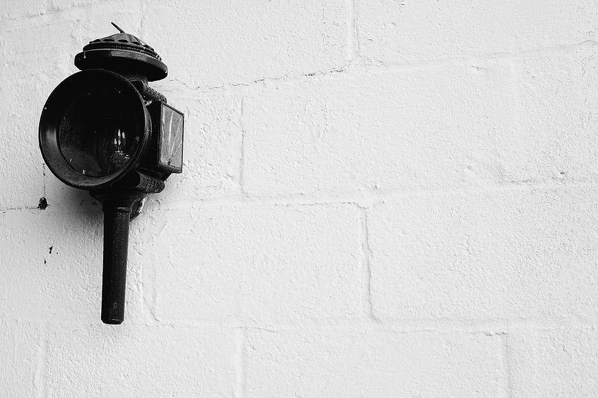 Vintage black lantern on white brick wall