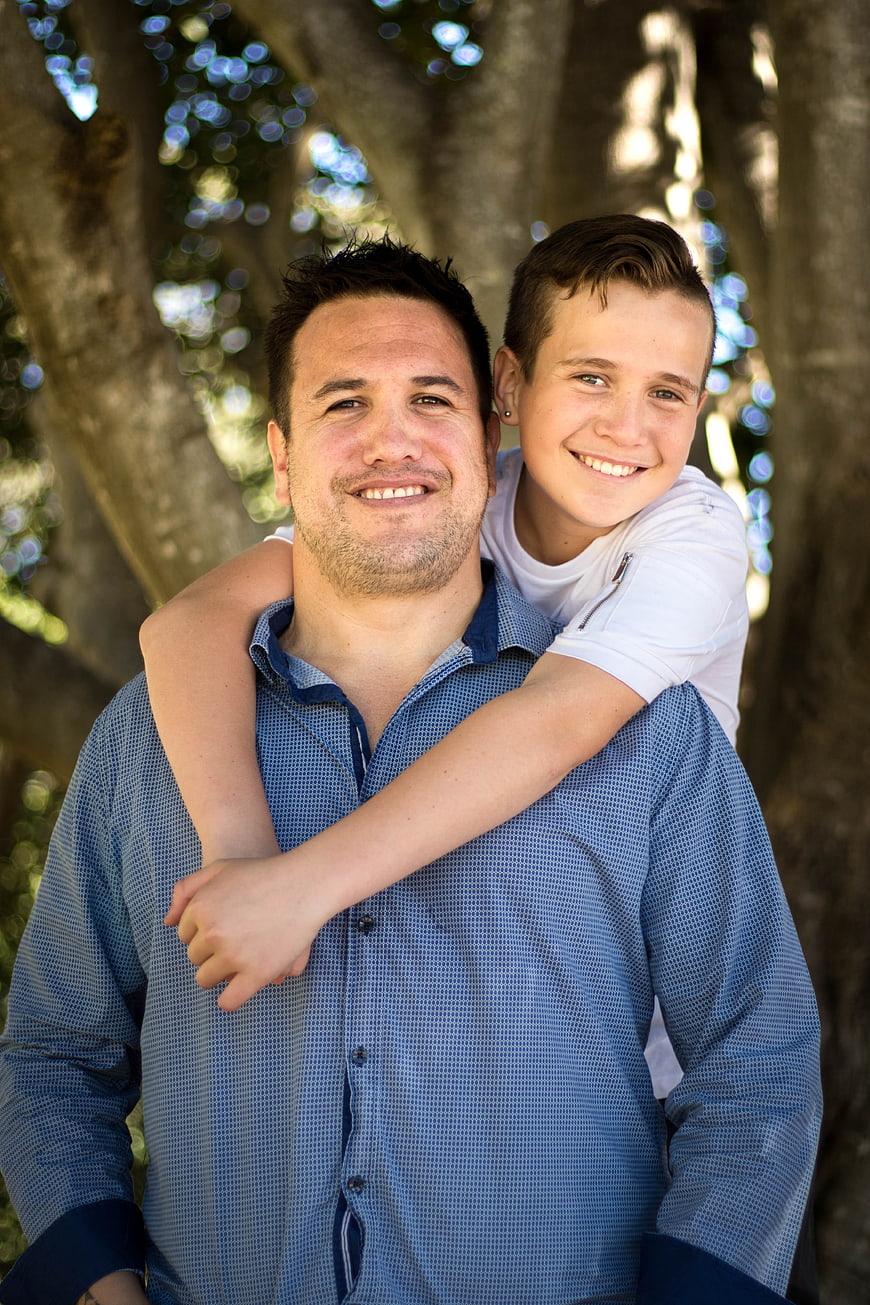Happy Father and Son Hugging Outdoors in Park