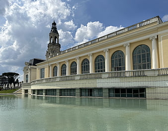 Classical yellow building with tower and reflection in water