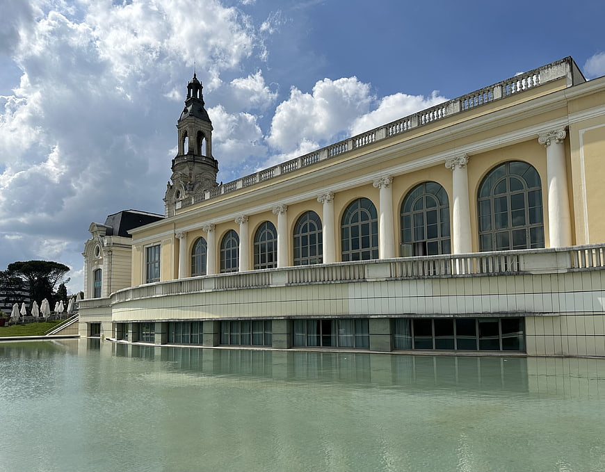 Classical yellow building with tower and reflection in water