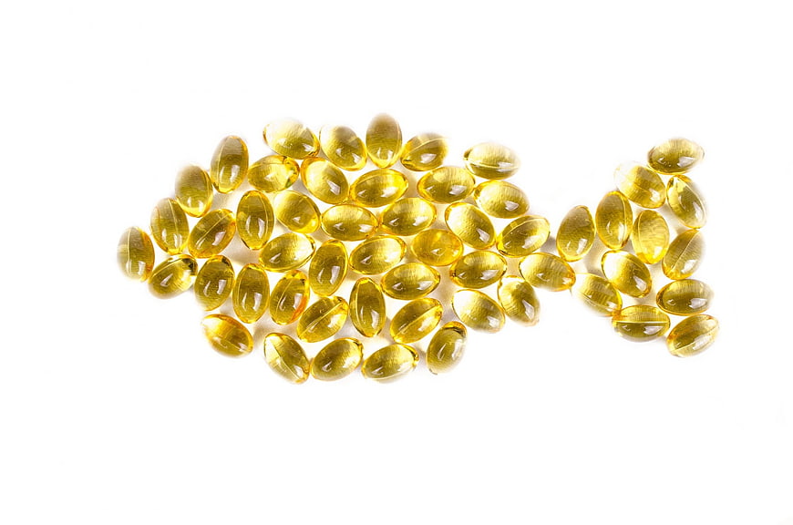 Yellow Fish Oil Capsules Arranged In Fish Shape On White Background