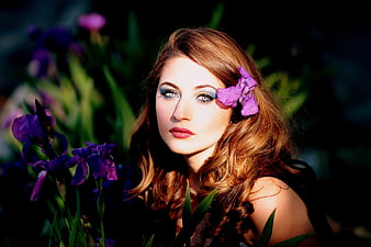 Beautiful woman with purple iris flower in hair