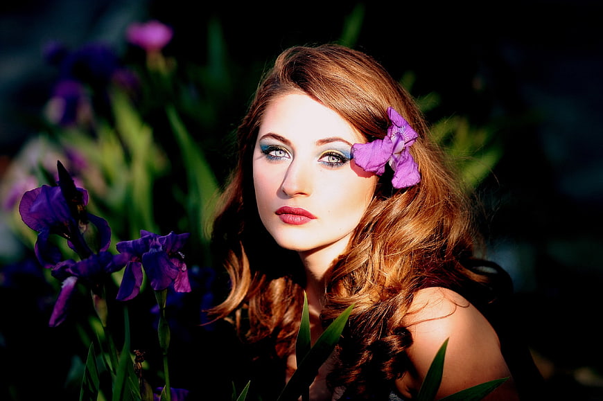 Beautiful woman with purple iris flower in hair