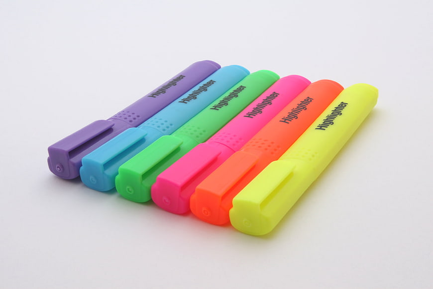 Six Colorful Highlighter Pens Arranged Diagonally On White Background
